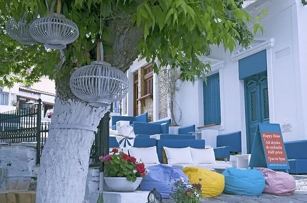 Greece, Sporades, Skiathos island, Rock and Roll Bar, sofas and bean bags on stone steps under plane tree at the old port