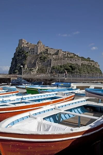 Italy, Ischia, Campania, Castello Aragonese, medieval castle built on volcanic rock, with small boats in forefront