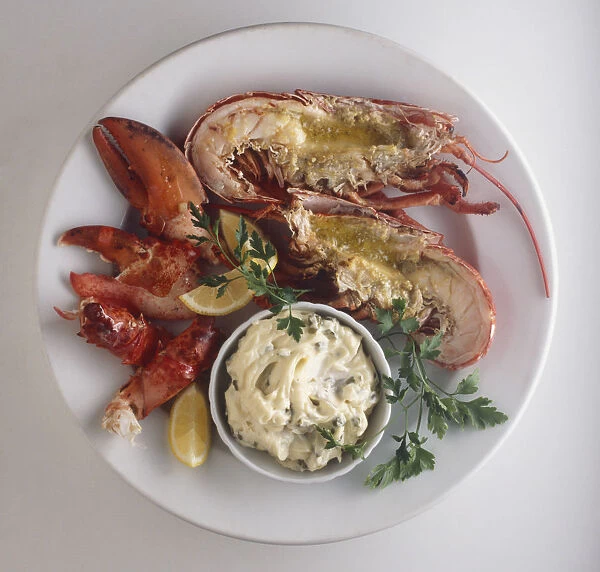 Langosta a la parrilla, lobsters served with bowl of mayonnaise, lemon slices and herbs, view from above