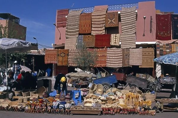 Morocco, Marrakech, Rahba Kedima, local crafts, produce, and carpets on display in street