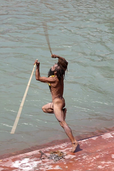Naga sadhu jumping into the river Ganges on the occasion of Somvati Amavasya, a no moon day in the traditional Hindu calendar