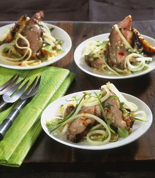 Seared duck served on plate with mango salad and green papaya