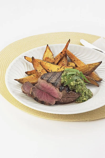 Seared fillet of beef with vegetables on plate, close-up