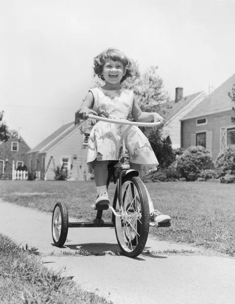 Smiling girl on tricycle