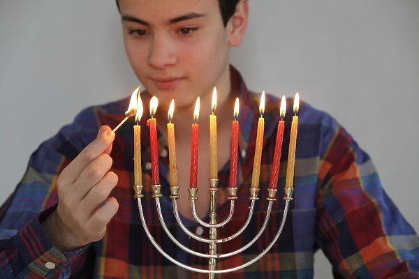 Teenager lighting Hannuka candles