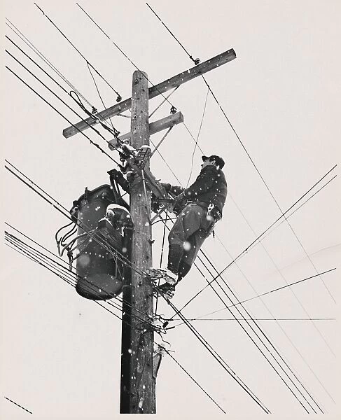 Worker fixing electric cable in snow