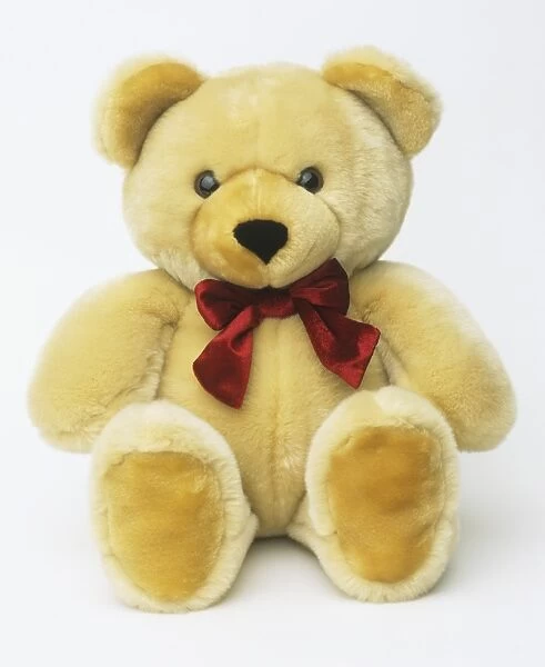 Yellow teddy bear with red bow tie, close up