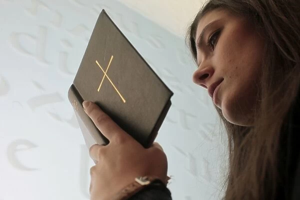Young woman reading the bible in a church
