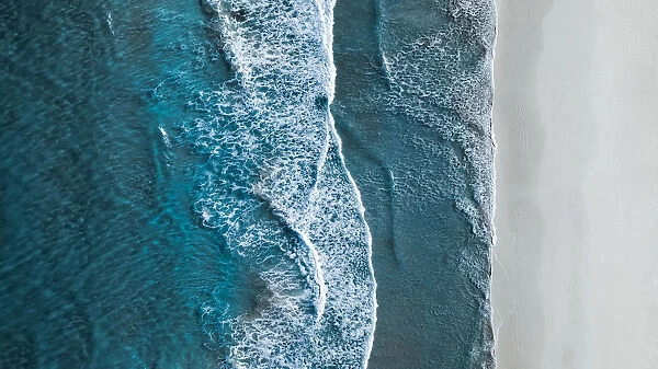 Drone shot showing waves rolling onto a beach, Esperance, Australia