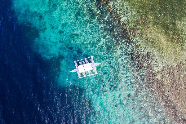 Aerial view of outrigger boat and coral reef, Philippines