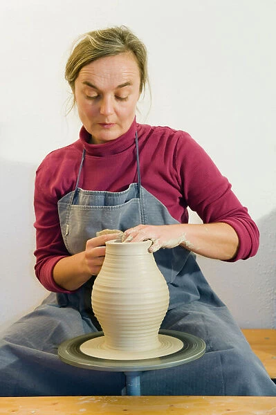 Ceramic artist working in her workshop with a potters wheel, turning a vase, Geisenhausen, Bavaria, Germany, Europe