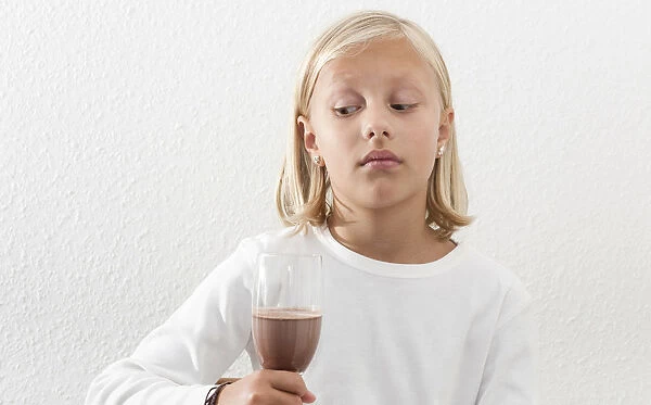 Eight-year-old girl viewing her drink skeptically