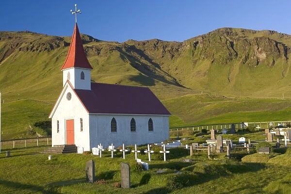 Iceland, church and graveyard in mountainous landscape