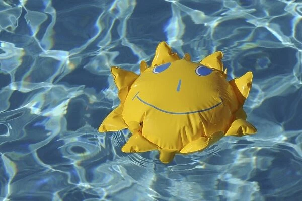 Toy sun floating in a swimming pool