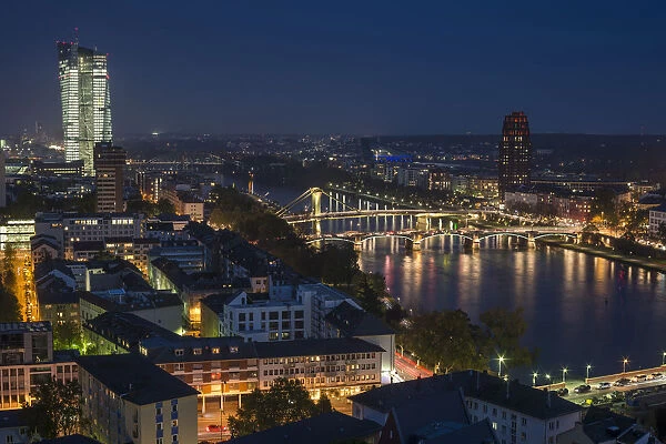 View of the city and the Main river from the top of the cathedral, of the new illuminated skyscraper of the European Central Bank, Flosserbrucke bridge and Ignatz Bubis Brucke bridge, at dusk, blue hour, city centre, Frankfurt am Main, Hesse, Germany