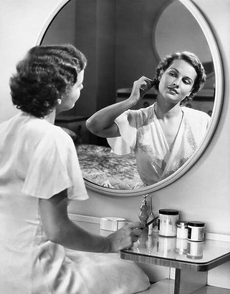 Woman doing hair in front of mirror, (B&W). Available as Framed Prints,  Photos, Wall Art and other products #12301023