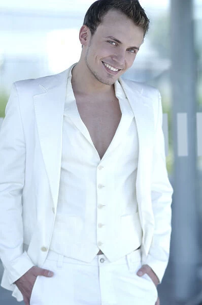 Young man wearing a white suit, smiling