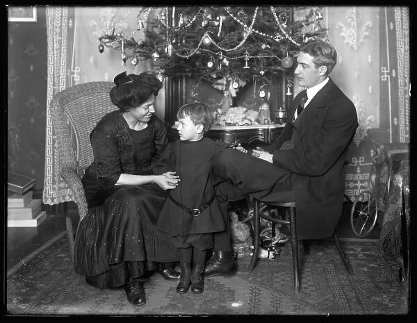 Dan Seymour and family in informal pose, seated beneath a Christmas tree