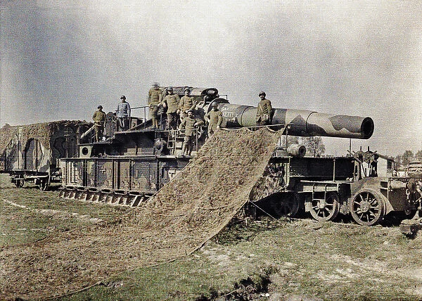Eight French soldiers are camouflaging a 370 mm railway gun with the inscription