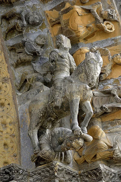 A rider on his horse, supported by a character - Sculpted detail of the vault of the portal of the church of Sainte Marie (11th century) in Oloron Sainte Marie (Pyrenees Atlantiques, Aquitaine)