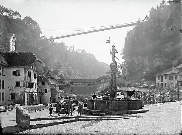 Switzerland, Canton of Fribourg, DI, Fribourg: rue de la Palme with fountain of Fidelite and at the bottom, the suspension bridge of Fribourg, 1895