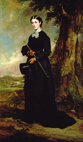 Young woman wearing a black riding habit and standing in a landscape