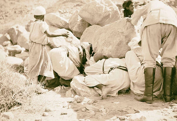 Men boy looking under large boulders 1925 Egypt
