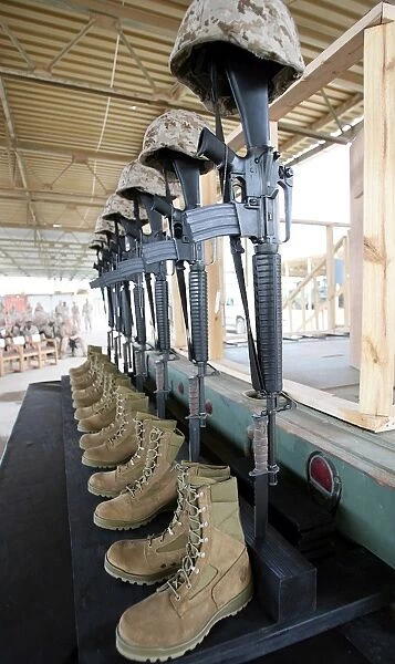 Boots, rifles, dog tags, and protective helmets stand in solitude to honor fallen
