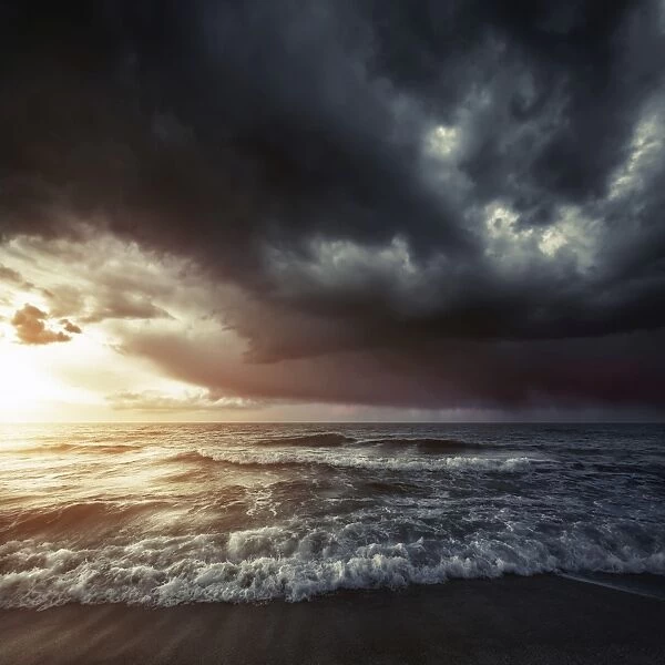 Bright sunset against a wavy sea with stormy clouds, Hersonissos, Crete