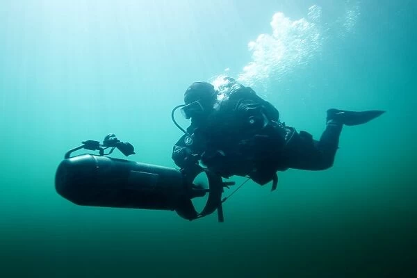 Combat diver navigates the waters using a diver propulsion vehicle