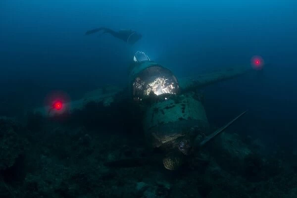 Diver exploring the wreck of a Japanese Navy Seaplane in Palau, Micronesia