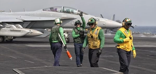 An EA-18G Growler is guided into catapult aboard USS George H. W. Bush