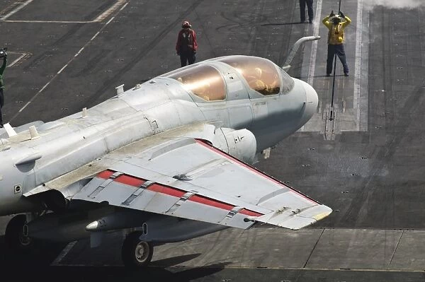 An EA-6B Prowler is guided onto a catapult aboard USS Harry S. Truman