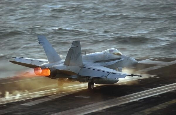 An F  /  A-18C Hornet launches from the flight deck of USS Theodore Roosevelt