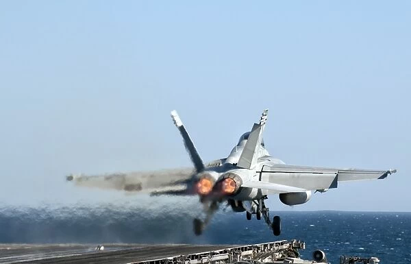 An F  /  A-18F Super Hornet launches from the flight deck of aircraft carrier USS Nimitz