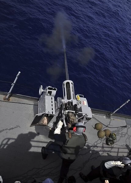 Gunner fires a Mark 38 machine gun aboard USS Frank Cable