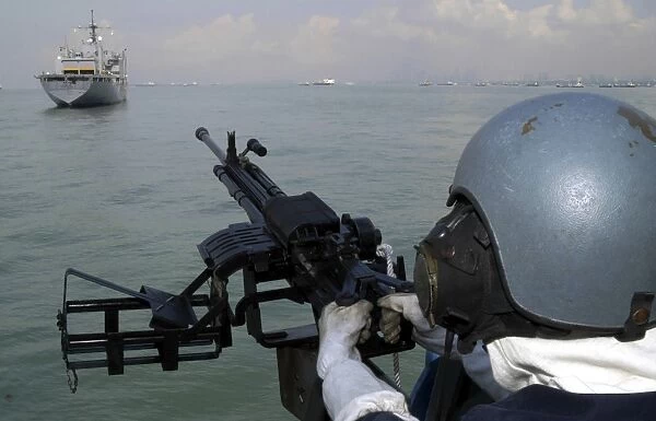 A gunner keeps his sight on the Military Sealift Command combat stores ship USNS Concord