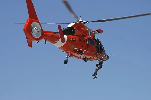 An HH-65C Dolphin demonstrates a helicopter rescue