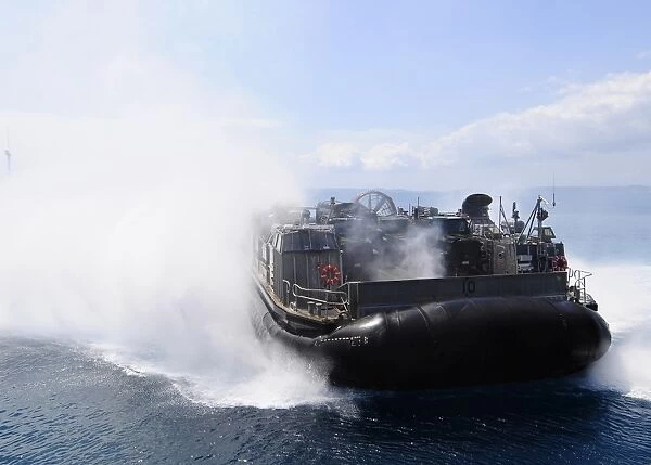A landing craft air cushion travels at high speed off the coast of Okinawa, Japan