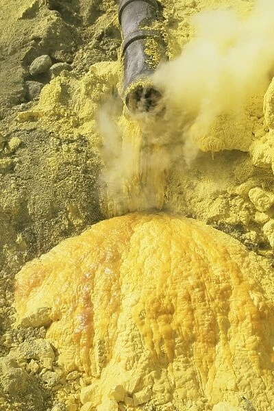 Liquid sulphur running out of a pipe in Kawah Ijen Volcano Sulphur Mine, Java, Indonesia