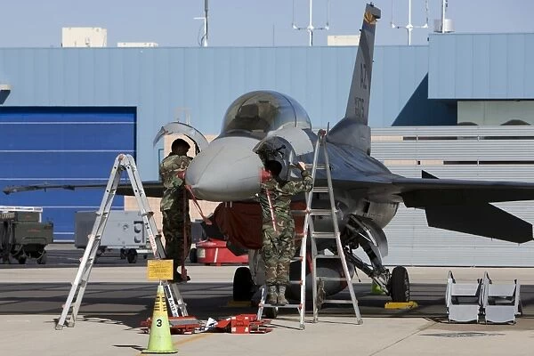 Maintenance personel work on an F-16 Fighting Falcon