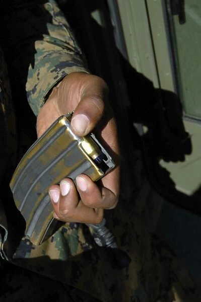 A Marine loads blank ammunition rounds into a magazine