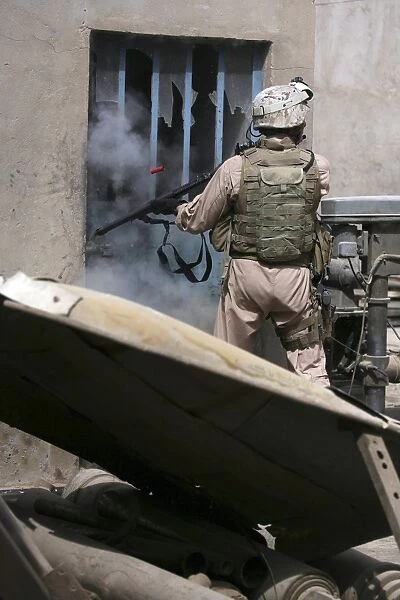 A military policeman uses a breaching round to open a lock