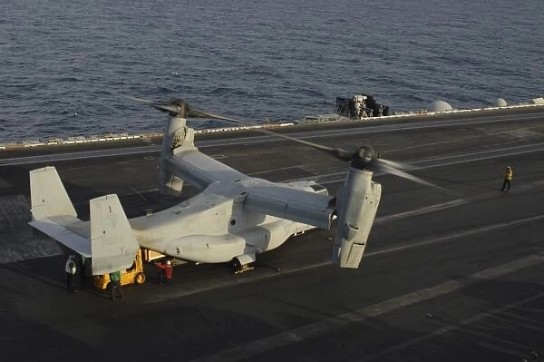 An MV-22 Osprey receives cargo on the flight deck of USS Harry S. Truman