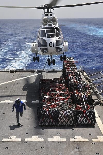 An SA-330J Puma helicopter picking up pallets of supplies from USNS Alan Shepard