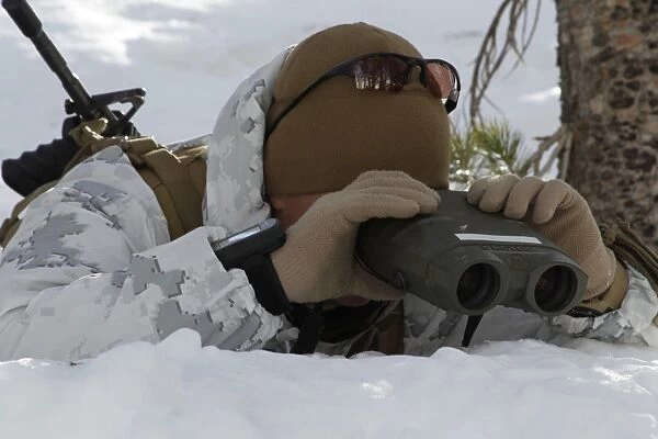 A scout sniper watches to see any position changes in his target