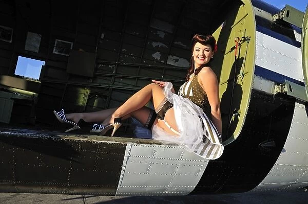 Sexy 1940s style pin-up girl sitting inside of a C-47 Skytrain aircraft