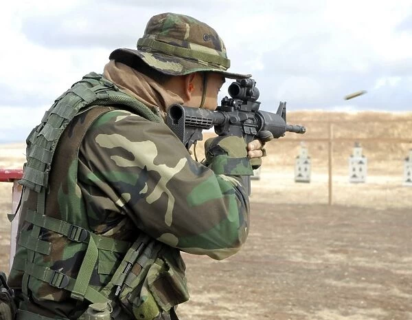 A soldier fires rounds down range at an M-4 qualification shoot