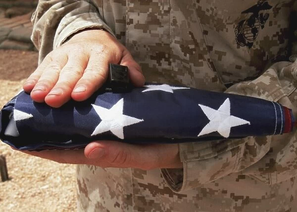 A soldier holds the United States flag