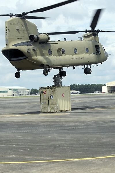 Soldiers attach a container to a CH-47F Chinook slingload hook